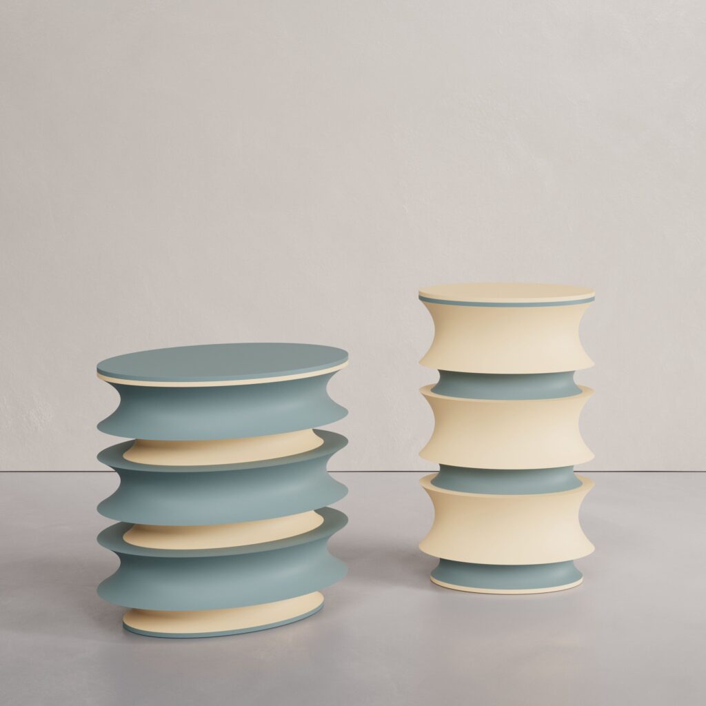 The Demi-Sec Twin-Tables in lacquered MDF by Cadenza Visioni by Annette Wernick, showcasing a sage blue and cream beige stacked hourglass design.